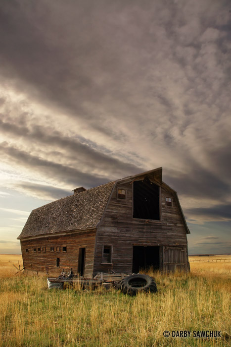 Clouds gather over a dilapidated barn in the Southern Alberta prairies.