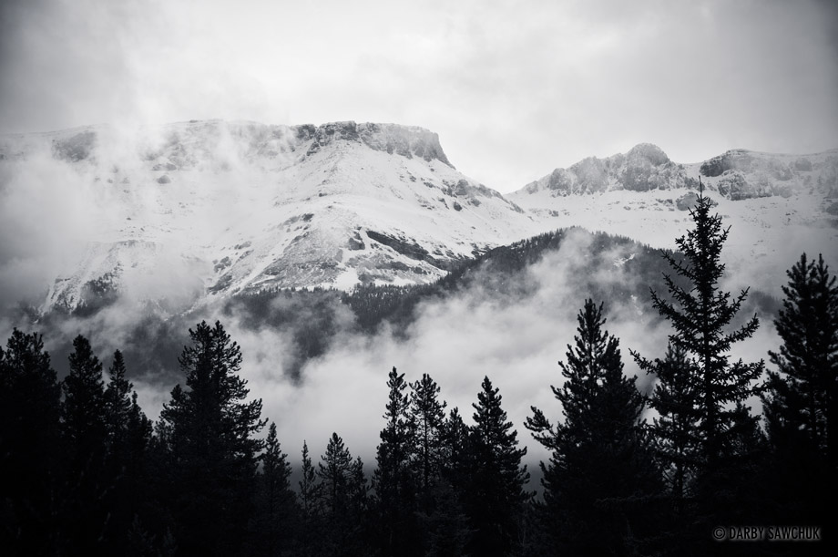 Clouds wash over the snow-covered peaks of the Alberta Rockies.