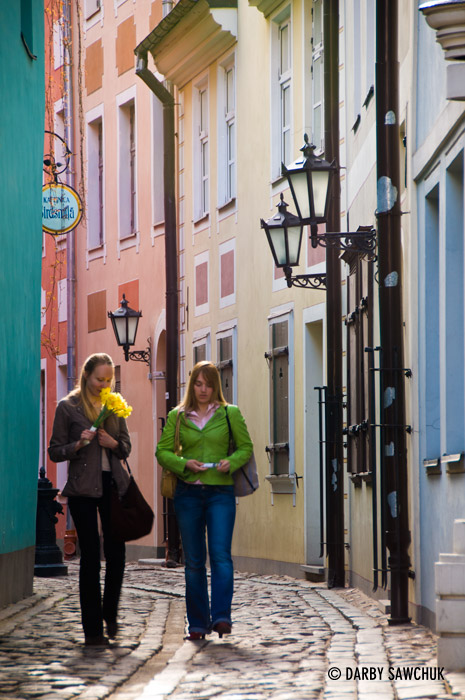 Girls walk through one of the colourful, cobbled streets of Riga, Latvia.