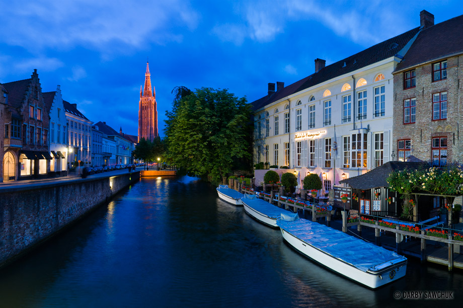 The Church of Our Lady rises above the Rozenhoedkaai canal in Bruges, Belgium.