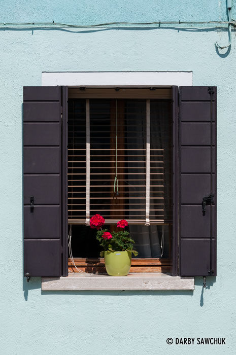 The window of a sky blue house in Burano, Italy.