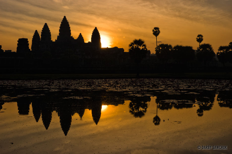 The sun rises behind the central structure of the temple of Angkor Wat in Cambodia.