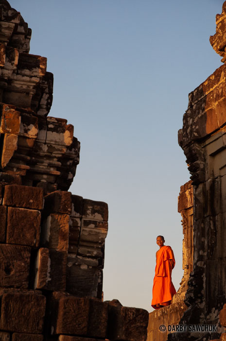 A novice Buddhist monk among the ruins of Phnom Bakheng, in the Angkor region of Cambodia.