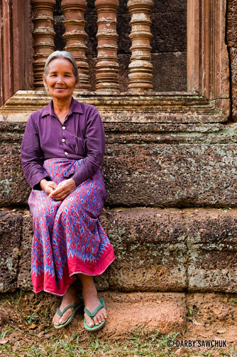 A Cambodian woman sits at Banteay Srei temple near Angkor Wat in Cambodia.