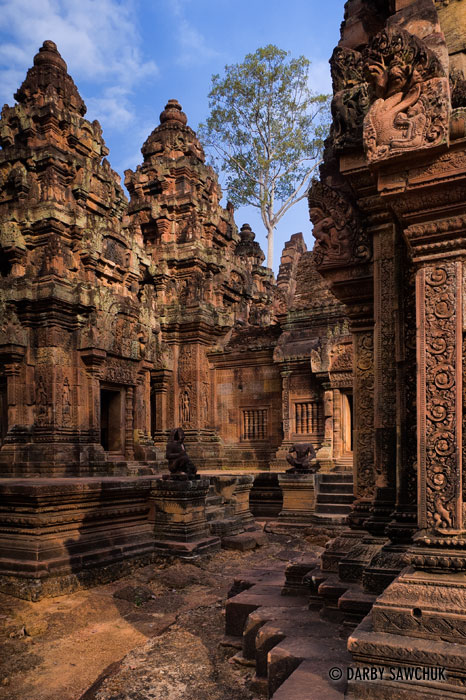 Banteay Srei features elaborate decorative wall carvings in its red sandstone construction.