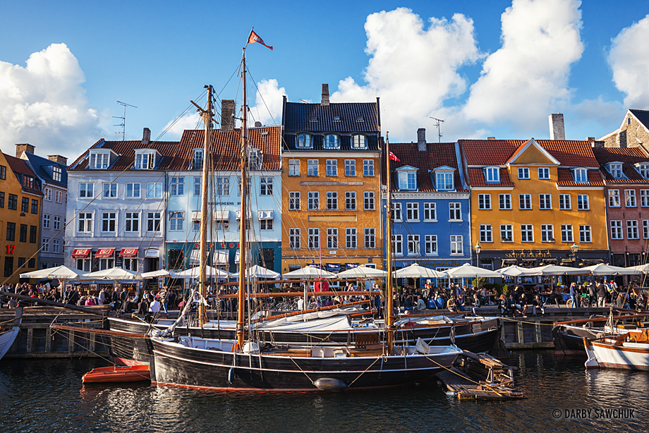 Brightly coloured facades overlook busy restaurants at the side of the Nyhavn Canal in Copenhagen.