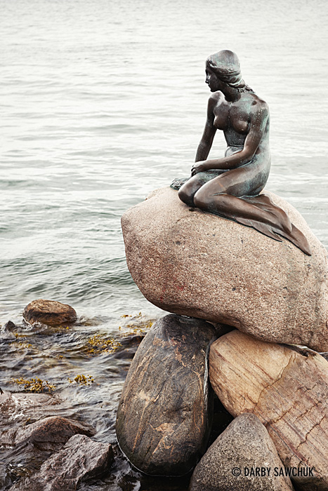 The famous Little Mermaid statue at the waterside of the Langlelinie promenade in Copenhagen, Denmark.