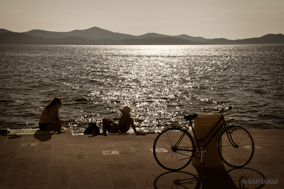 Sunbathers relax at the Sea organ in Zadar, a group of pipes that plays abstract music powered by the passing waves of the sea.