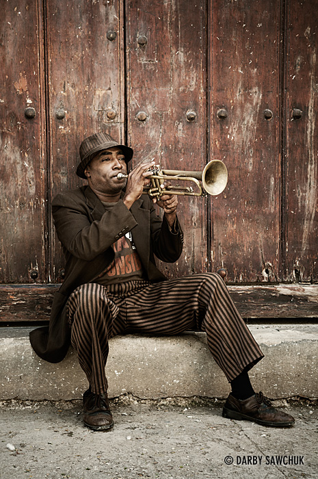 A trumpet player practices on a step in the old town of Havana, Cuba.