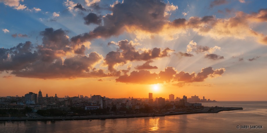 A panorama of the sun setting over the Havana city skyline.