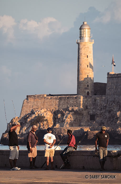 Fisherman try for a catch in Canal de Entrada (the entrance to the port of Havana) with the Lighthouse at the Castle of Tres Reyes del Morro in the background.