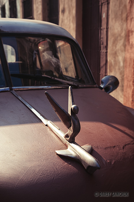 The hood ornament of one of Cuba's classic American cars.