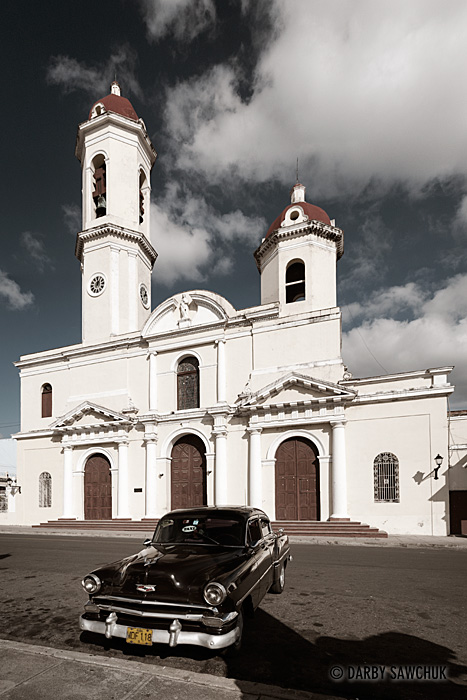 A classic American car is parked in front of the Cathedral of the Immaculate Conception (Cathedral de le Purisima Concepcion) in Central Cienfuegos, Cuba.