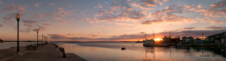 A panoramic view of the sun setting over the Bay of Cienfuegos from a pier near the centre of the city.
