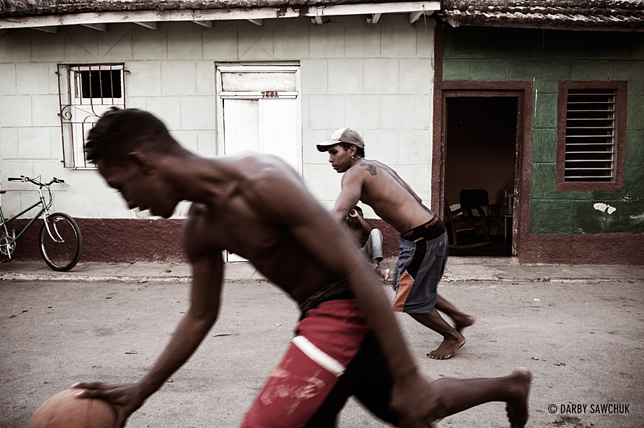 Teens play a game of keep-away basketball in the streets of Trinidad, Cuba.