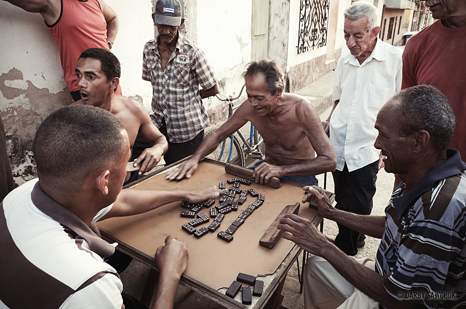 Men finish playing a game of dominoes in the streets of Trinidad, Cuba.