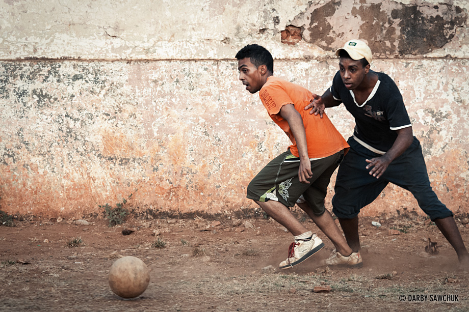 Teens play soccer/football in a dusty schoolyard in Trinidad, Cuba.