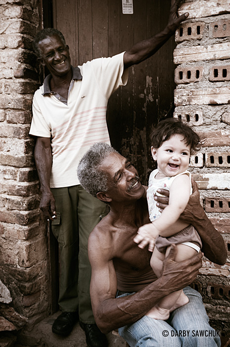 A family plays with a baby in Trinidad, Cuba.
