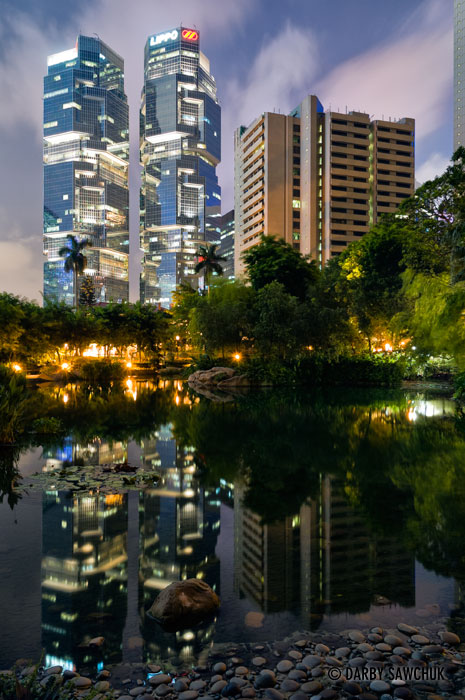 The Lippo Centre is reflected in the waters of a pond in Hong Kong Park in the Admiralty district.