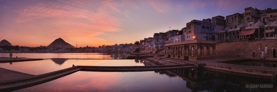 A panoramic view of Pushkar lake and its ghats with Ratnagiri Hill and the sunset in the distance.