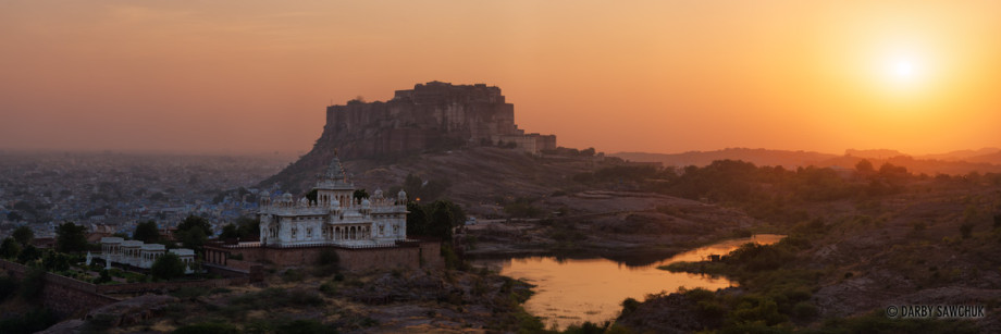 A panoramic view of Jodhpur's Mehrangarh Fort at sunset with Jaswant Thada in the foreground.