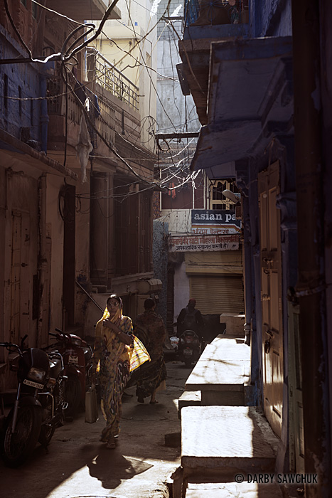 A woman walks through a narrow alley in Jodhpur.