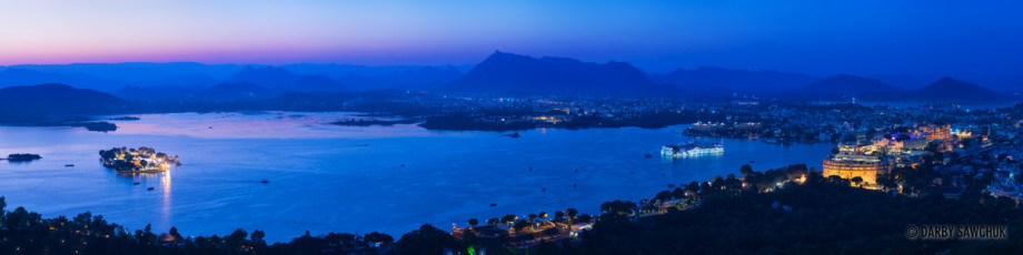 A panoramic image of Lake Pichola and its islands as well as the City Palace during the evening in Udaipur.