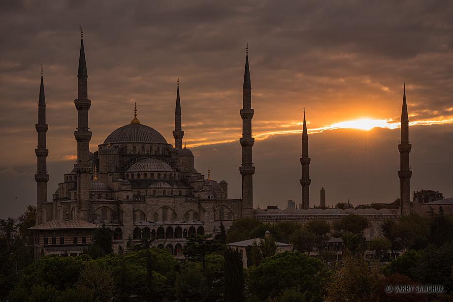 Evening sun bursts through a split in the clouds above the Sultan Ahmed Mosque, also known as the Blue Mosque, in Istanbul Turkey.
