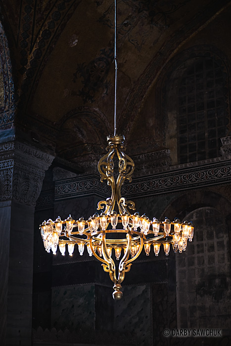 A chandelier of lamps illuminating the interior of the Hagia Sophia museum in Istanbul, Turkey.