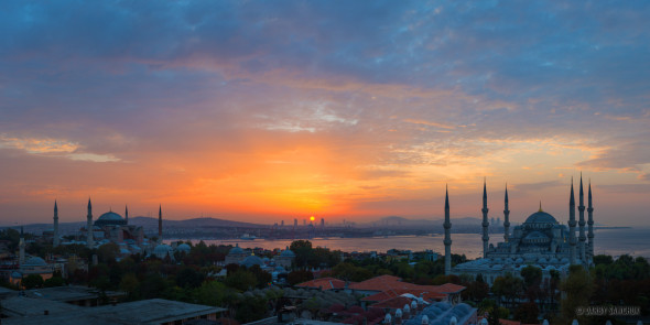 The sun rises over the Sultanahmet district of Istanbul, Turkey with Hagia Sophia on the left and the Blue Mosque on the right.