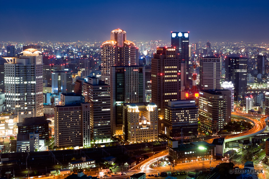 A nighttime view of the skyscrapers of the Osaka skyline.