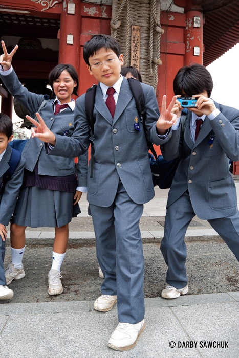 Japanese schoolchildren give the peace sign at Sensoji temple in Asakusa, Tokyo, Japan.
