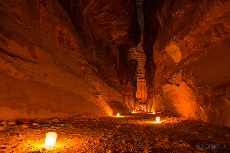 Candles light the narrow canyon walls of the Siq as well as the facade of the Treasury at its end.