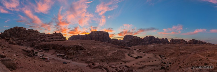 The sun sets over the landscape of Petra, Jordan.