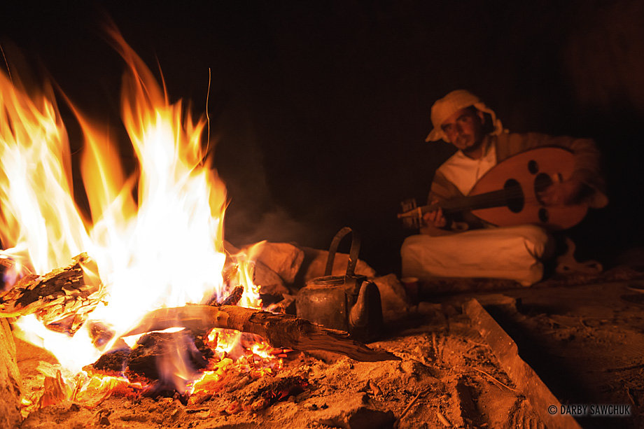 A bedouin musician plays an oud by firelight in Wadi Rum, Jordan.