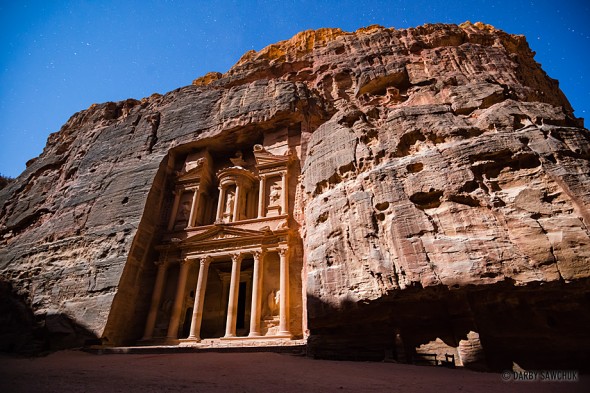 The Treasury of Petra lit up at night by moonlight in Jordan.