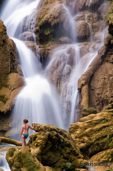 A girl admires one of the upper waterfalls at Kuang Si near Luang Prabang.