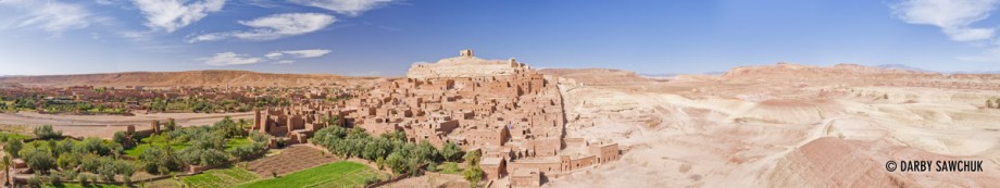 A panoramic view of Ait Benhaddou showing the oasis on one side and the barren desert on the other.