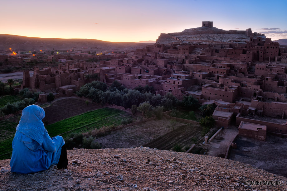 A Tuareg woman admires the view of Ait Benhaddou at sunset.