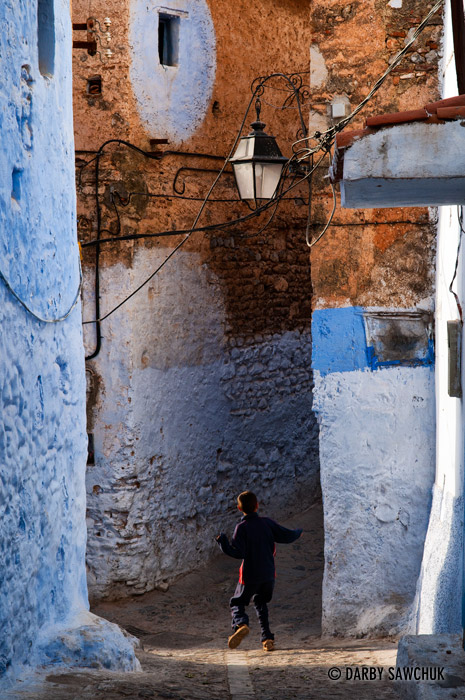 A boy runs through the streets of Chefchaouen, Morocco.