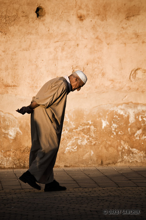 An elderly man walks through the Place Hedim, the heart of the Medina in Meknes, Morocco.