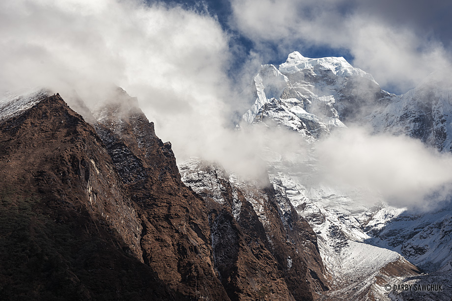 Clouds obscure the jagged, rocky peaks of mountains along the Everest Trail.