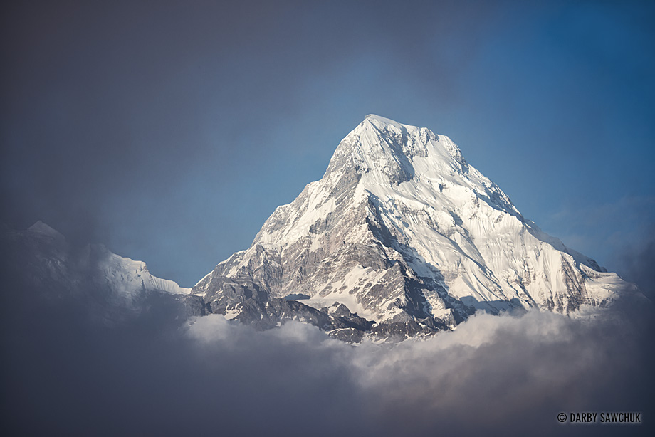 Clouds part to reveal one the south face of Annapurna South in Nepal.