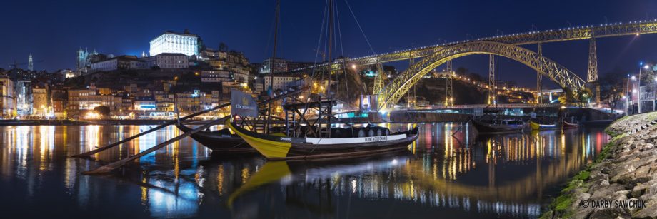 A panoramic view of rabelo boats floating in the River Douro in front of the Luís I Bridge from Vila Nova de Gaia