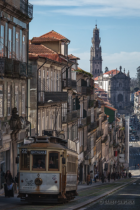 A tram ascends one of Porto's hills with the Clérigos Tower in the background.