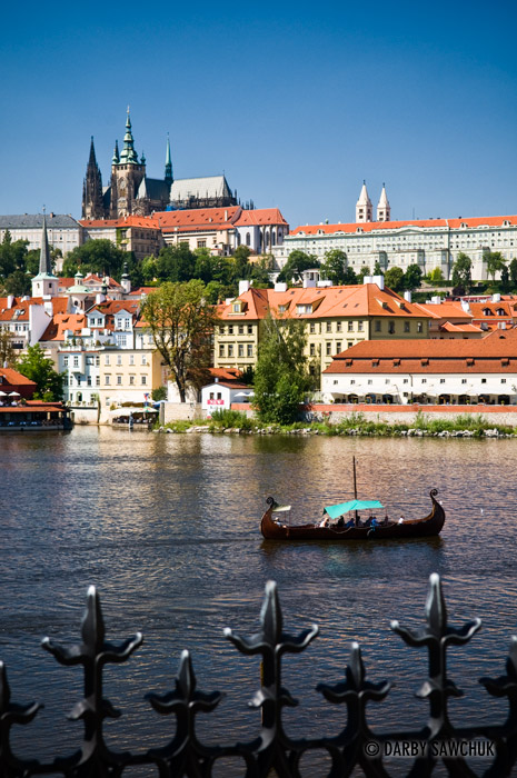 A boat on the river Vltava with Prague Castle in the background.