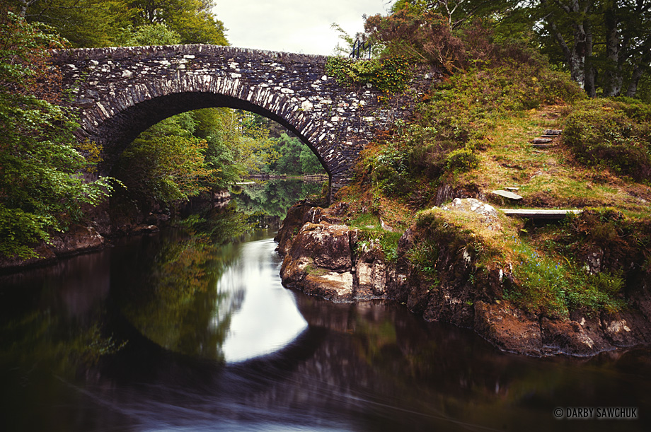 A stone bridge crosses the River Shiel in the Highlands of Scotland.