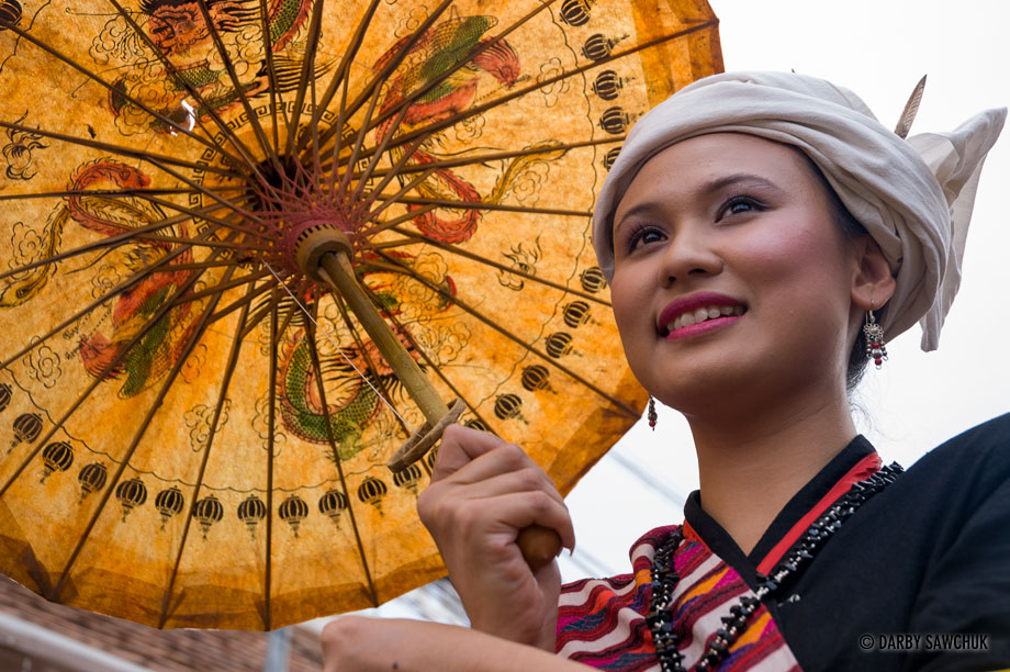 A woman carries an umbrella in a procession during the Songkran New Year festival in Chiang Mai, Thailand.