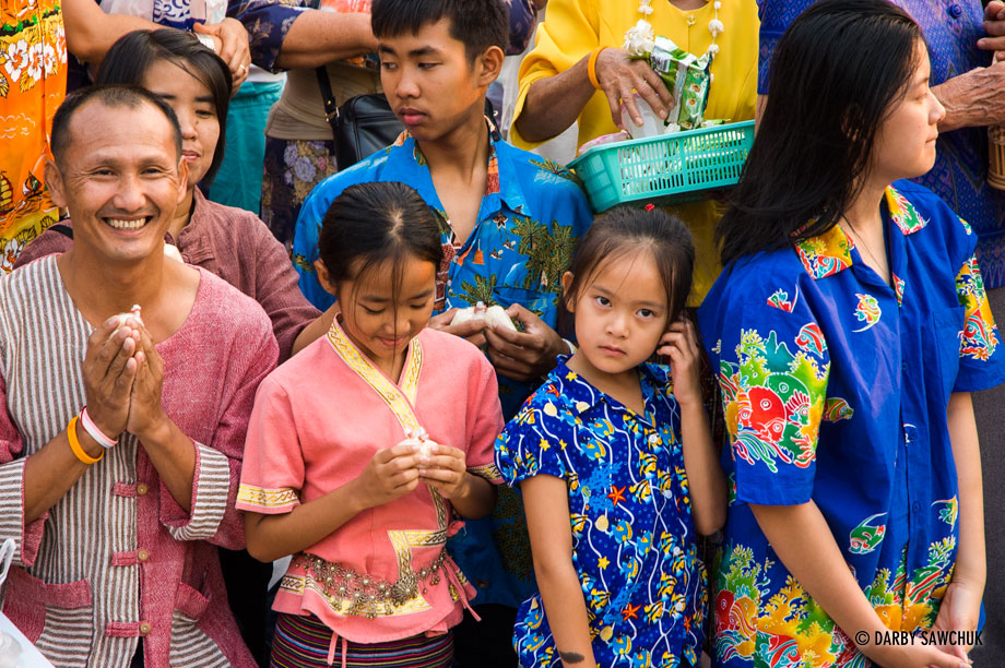 Worshippers prepare to give food to monks during merit-making ceremonies in the Thai New Year Songkran festival in Chiang Mai.