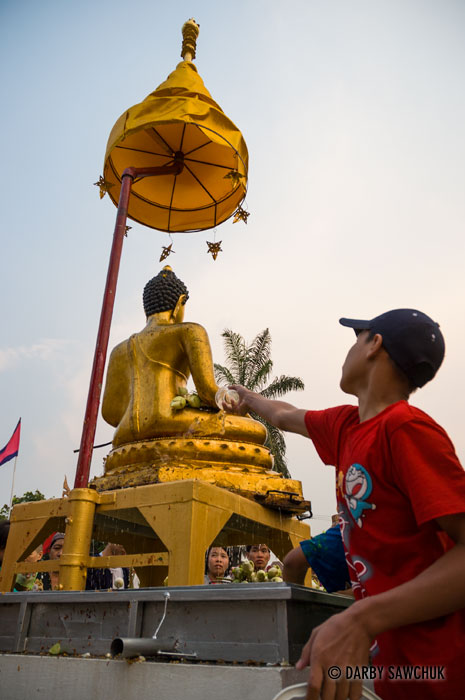A worshipper splashes water on the Buddha image at Wat Phra Singh in Chiang Mai, Thailand during Songkran.